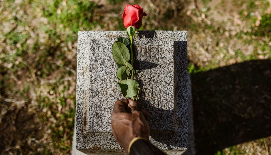 Una rosa sobre una tumba en el cementerio