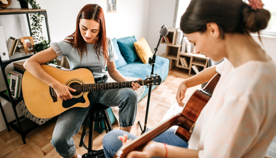Dos jovencitas tocando música con su guitarra