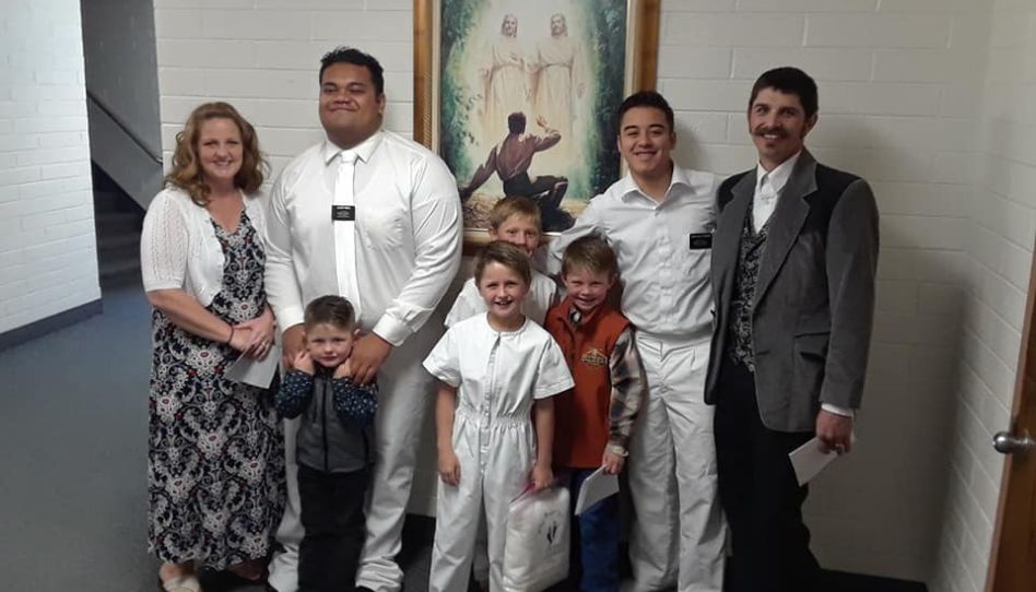 elder avila junto a su compañero de mision y una familia 