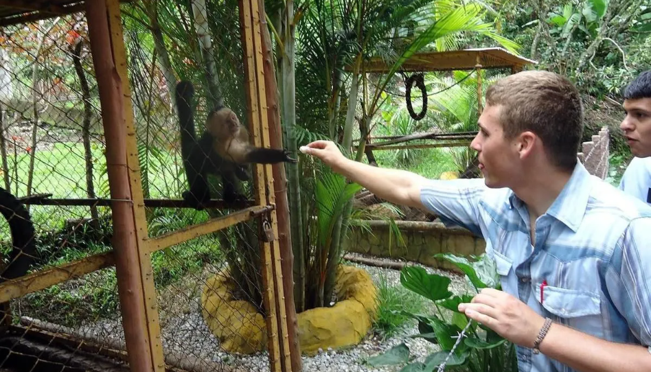 Élder Oakey dando de comer a un mono en el zoológico