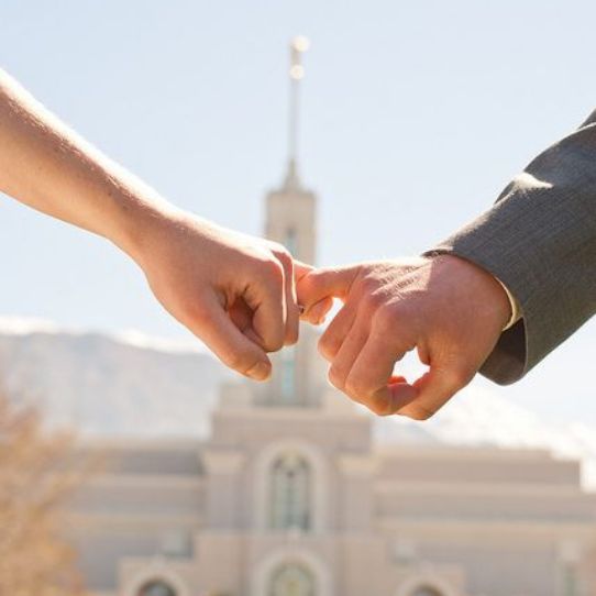 manos de esposos frente al templo