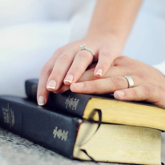 manos de esposos sobre las escrituras