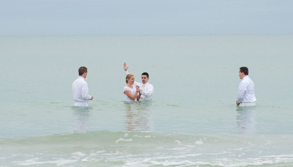 mujer siendo bautizada en la playa 